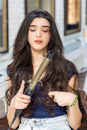 thoughtful-young-woman-holding-hair-dryer-looking-it-high-quality-photo_144627-75998