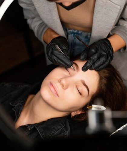 top-view-female-clinician-doing-eyebrow-treatment-woman_23-2148846014